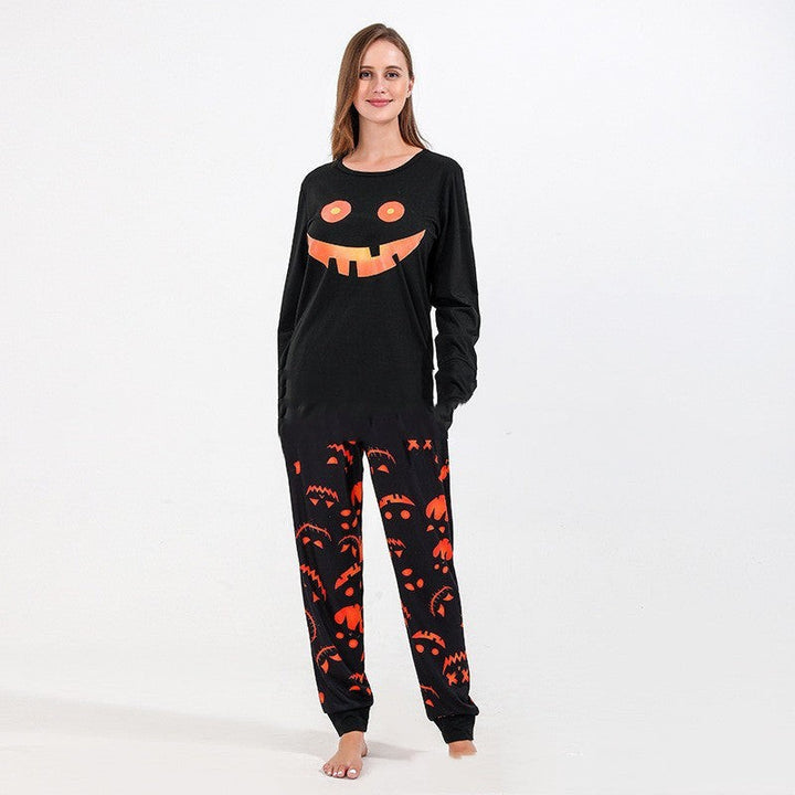 Woman modeling black pumpkin-grin pajama top paired with orange jack-o-lantern print jogger pants