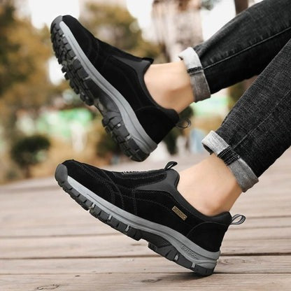 Black suede slip-on outdoor sneaker worn with rolled denim pants