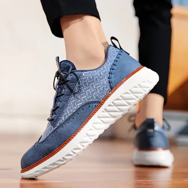 Blue leather sneaker worn on foot showing woven texture and lace closure