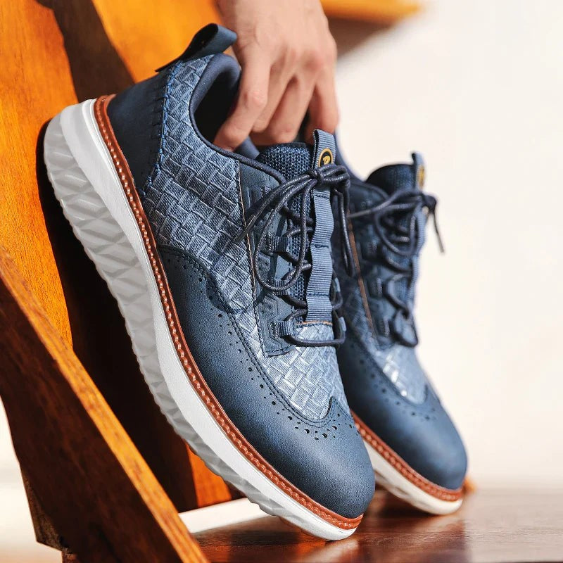 Blue woven leather sneaker held by hand showing textured upper detail