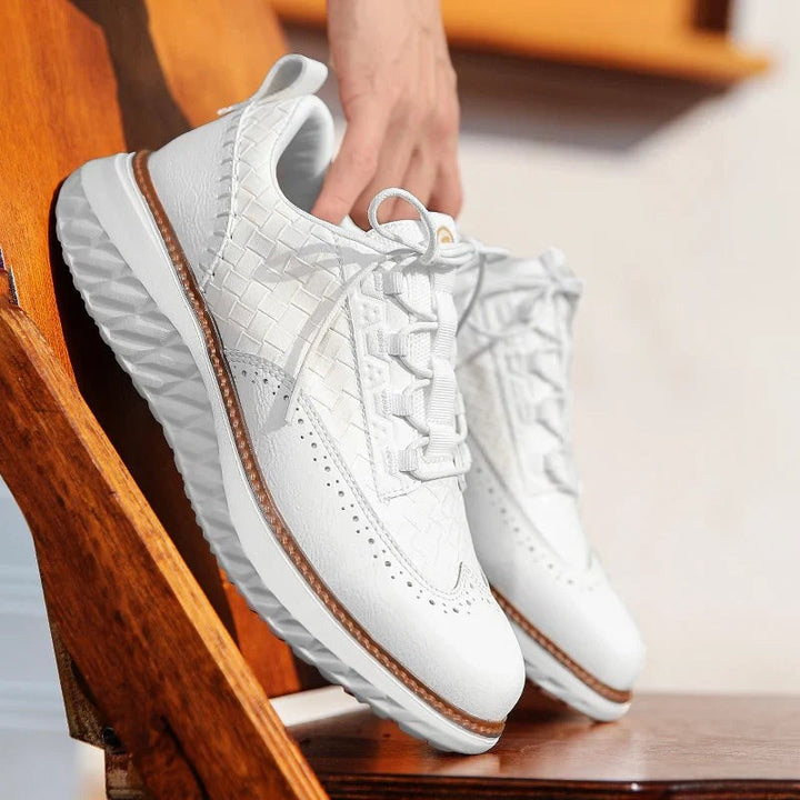 White woven leather sneaker held by hand showing lace-up front design