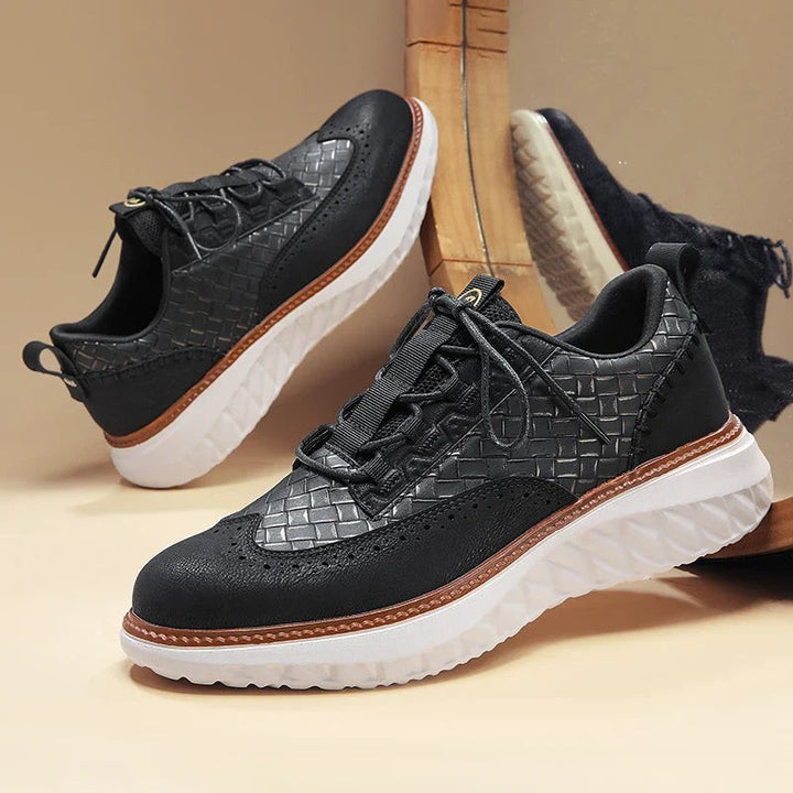 Pair of black woven leather sneakers with tan trim and chunky outsole
