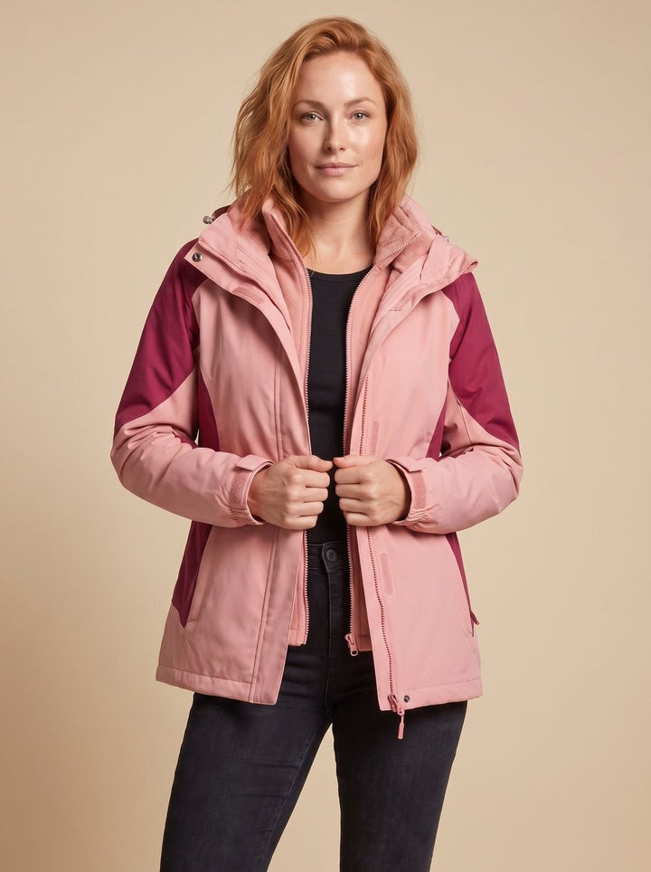 Woman wearing pink and berry colour-block 3-in-1 hooded softshell jacket, unzipped over fleece