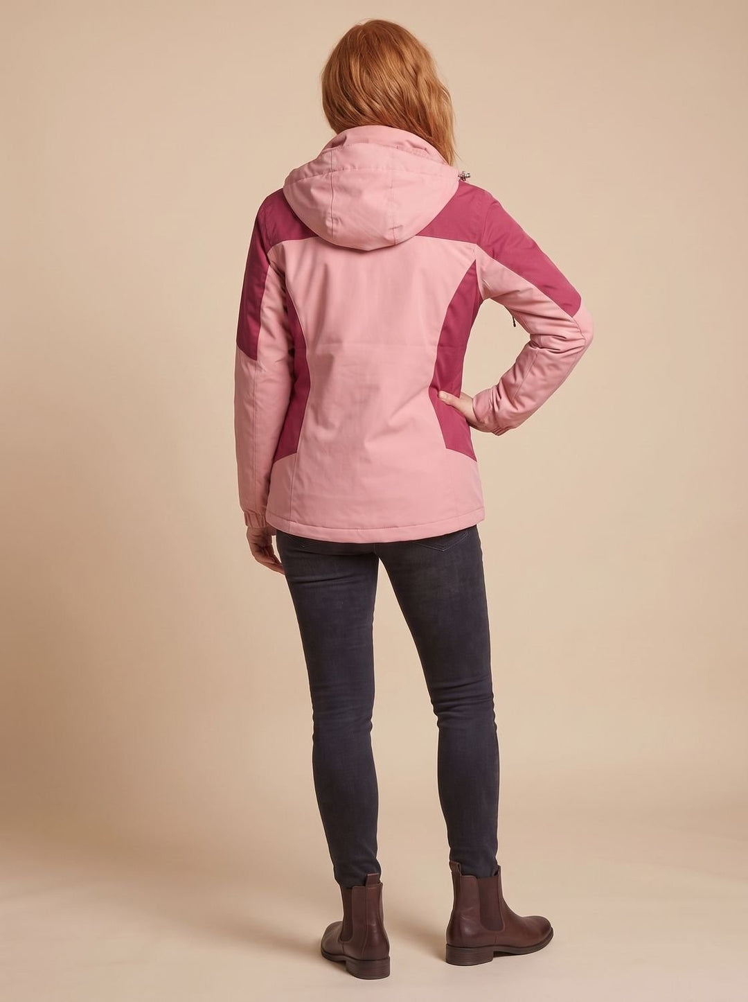 Rear view of pink and berry colour-block softshell jacket with hood, worn with jeans