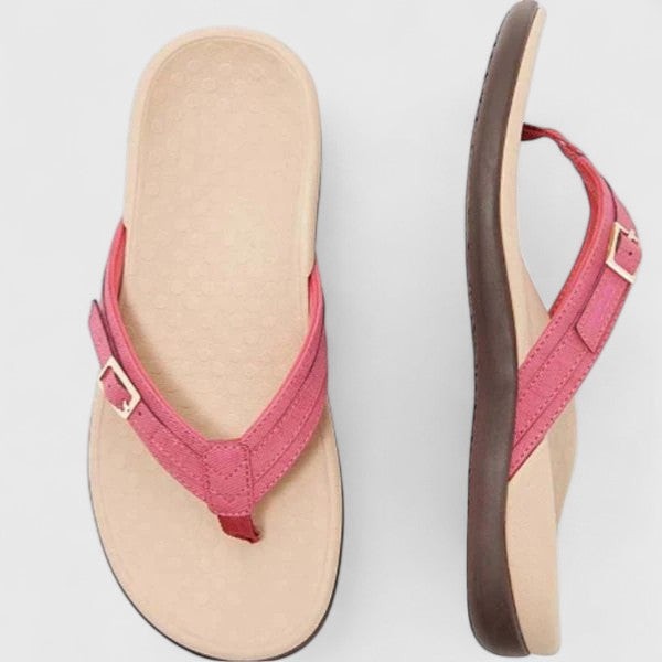 Pink leather flip-flop sandals featuring a stitched buckle strap design