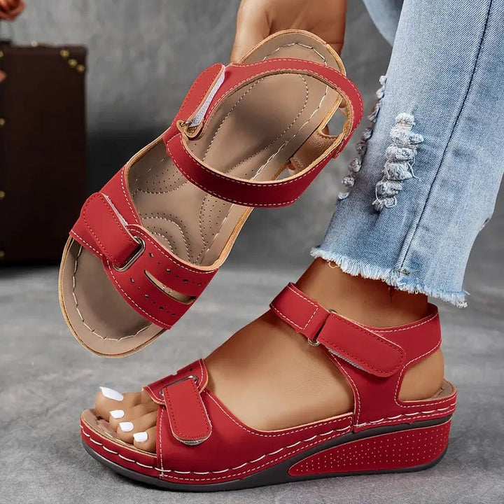 Red orthopedic sandals featuring open toe and hook-and-loop ankle closure