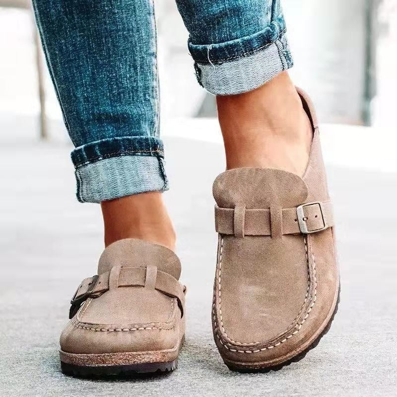 Beige suede slip-on clogs with adjustable buckle and stitched moc toe
