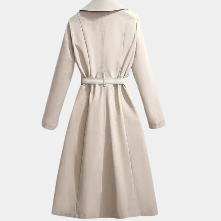 Beige belted trench coat, rear view showing tailored waist and flared midi hem