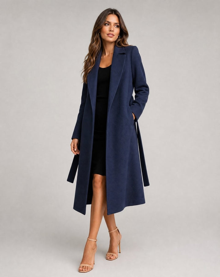 Navy belted long coat worn over black midi dress with tie waist