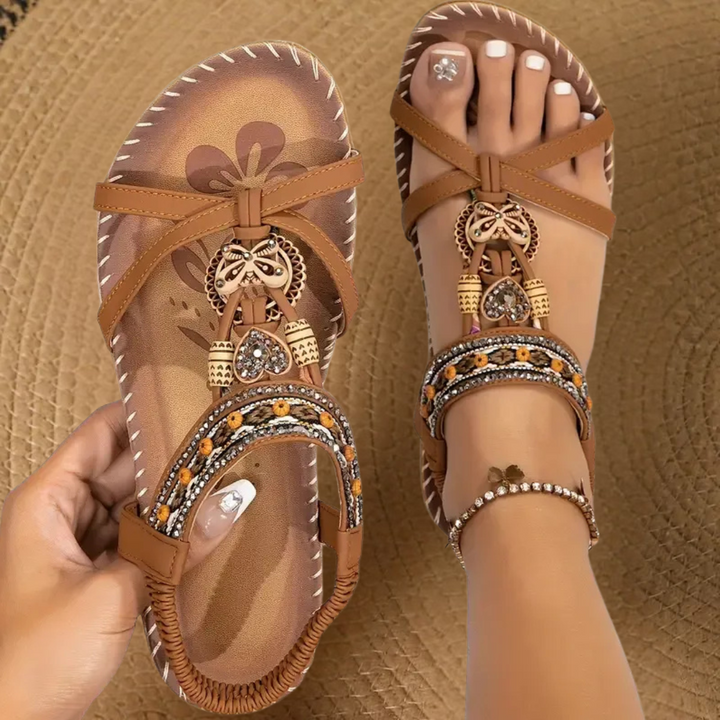 Tan flat sandals with woven straps and beaded ethnic trim