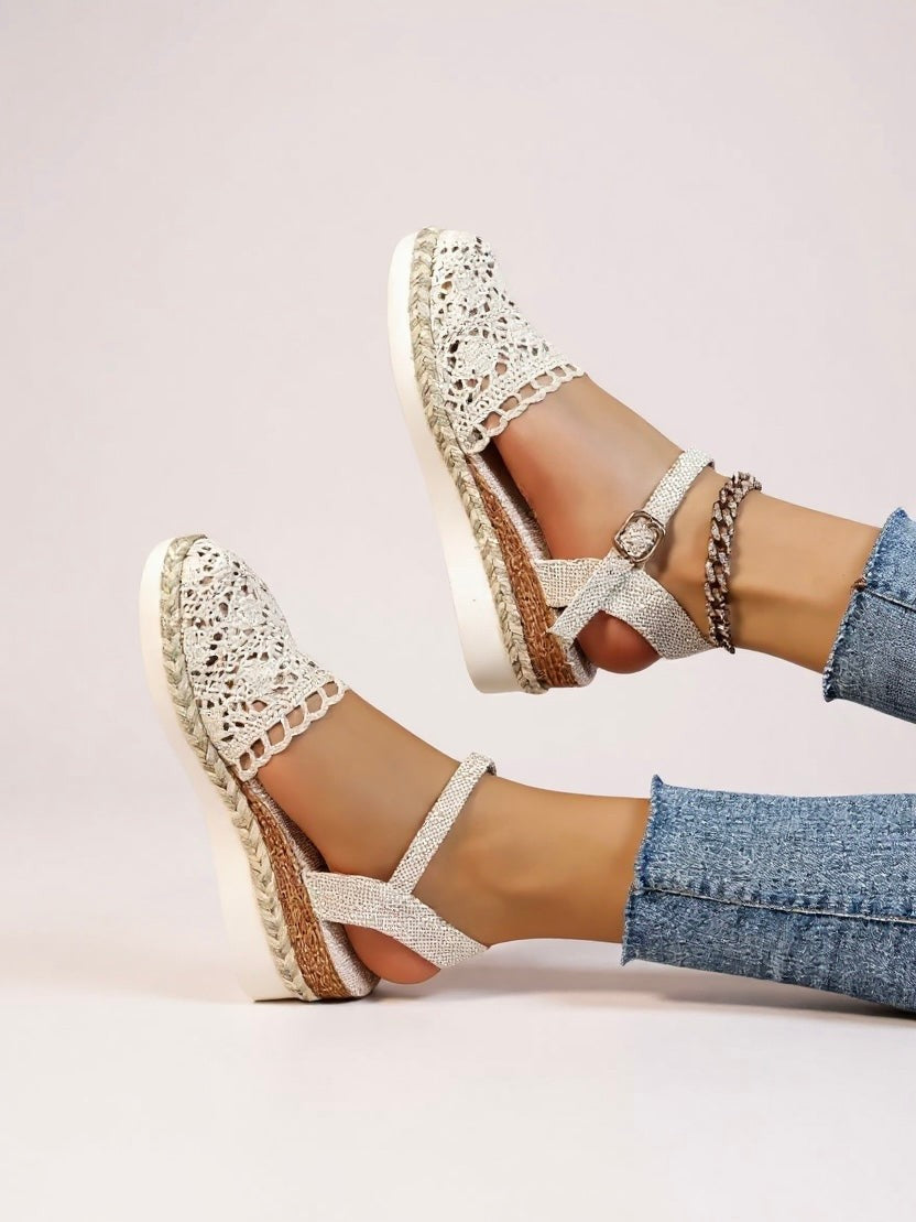 Pair of white crochet wedge sandals with crisscross ankle straps