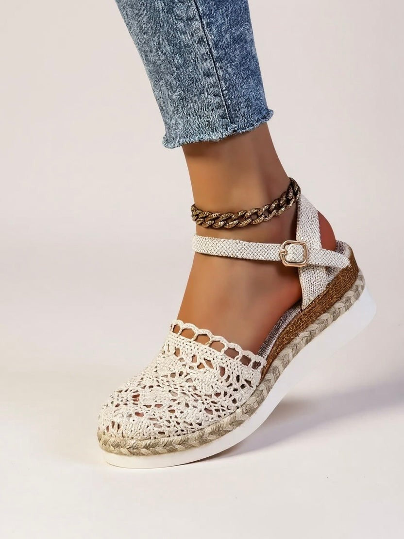 Close-up of white crochet espadrille sandal with gold ankle chain accent