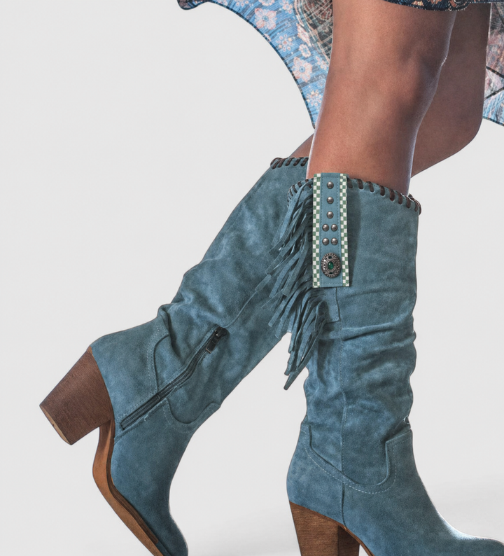 Slate blue suede knee-high boots with whipstitch edge and fringe accent
