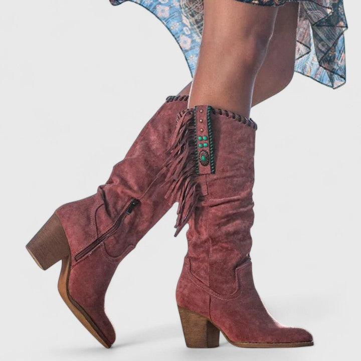 Mauve suede knee-high boots showing side zipper and fringe detailing