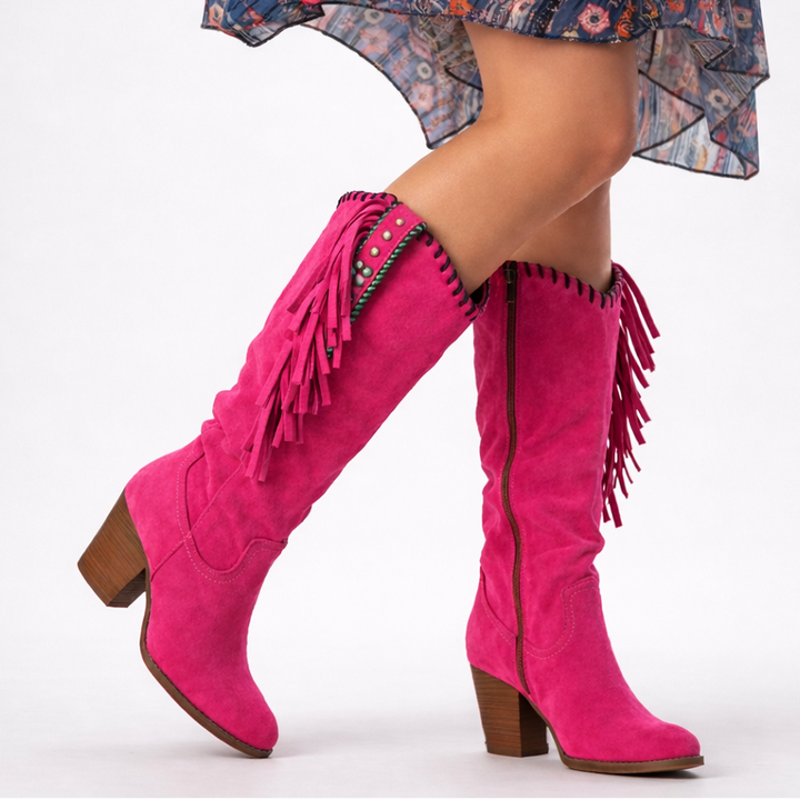 Hot pink suede knee-high boots with fringe trim and wooden block heel