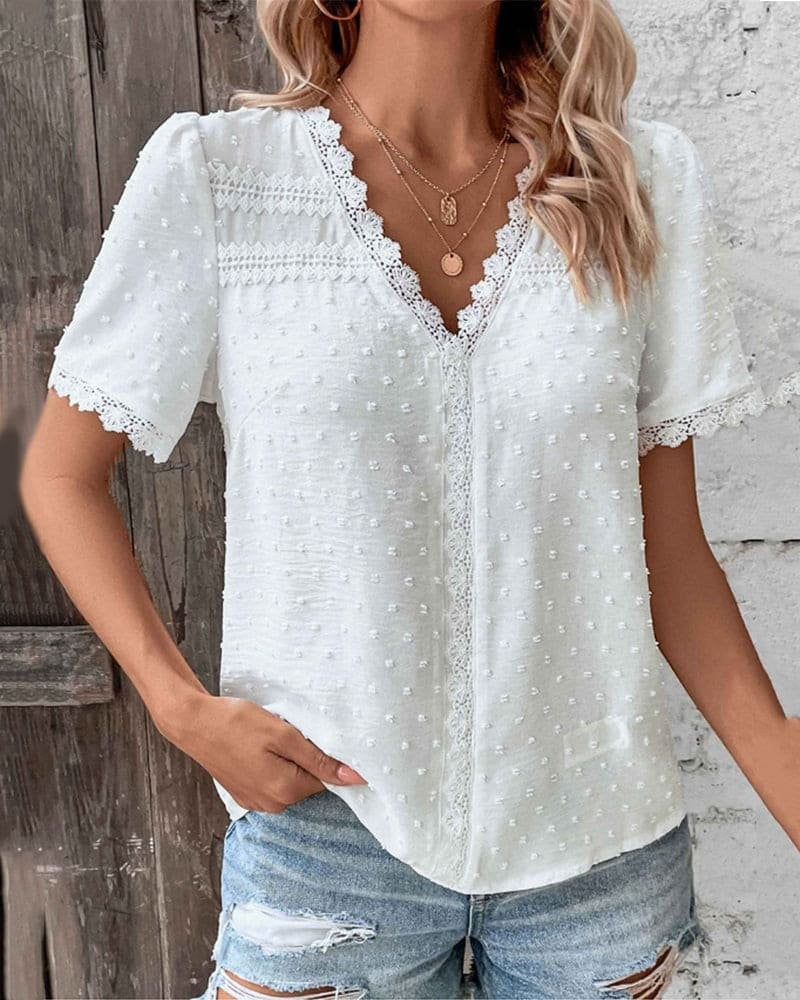 Close-up of white lace-trim V-neck blouse with textured Swiss dot fabric