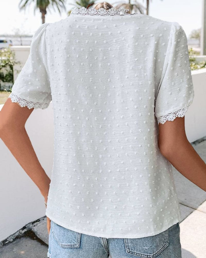Back view of white textured blouse with lace-edged short sleeves