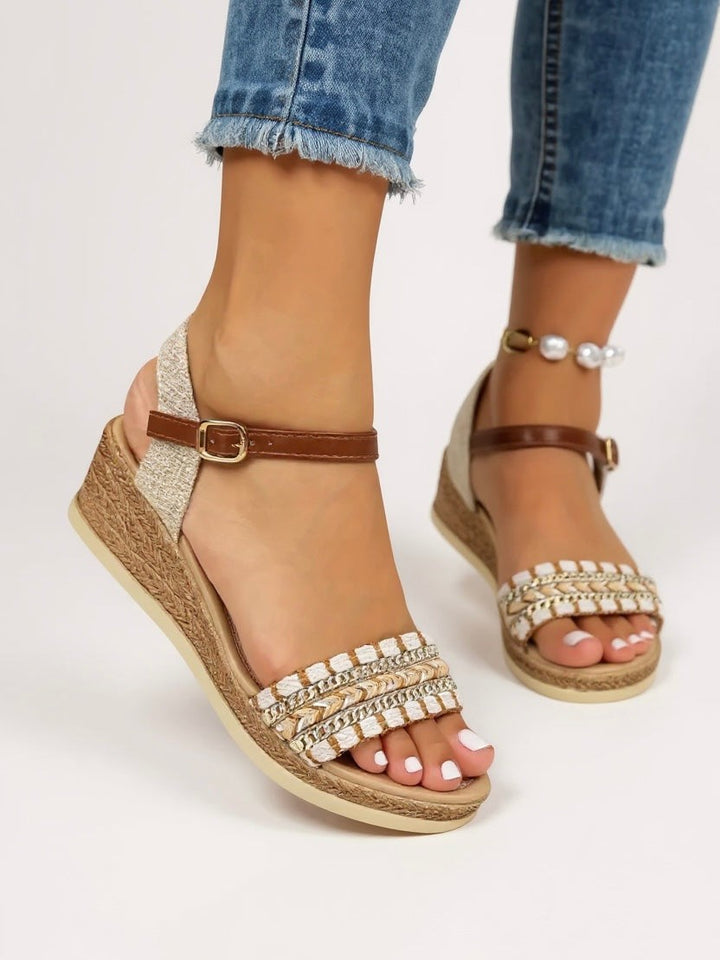 close-up of woven strap wedge sandals with metallic chain and stitched detail