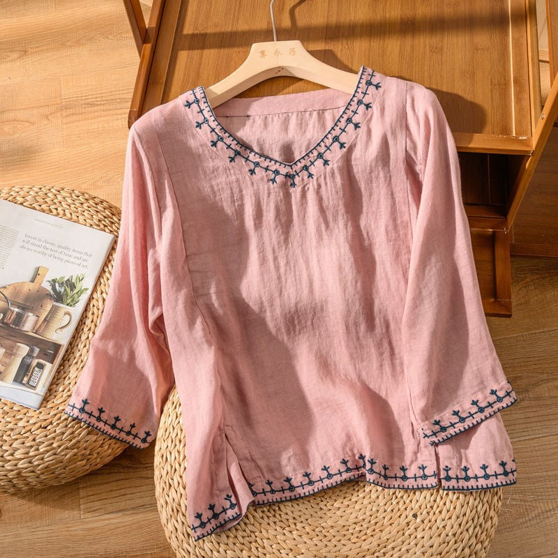 Pink linen blouse featuring embroidered trim and flared cuffs