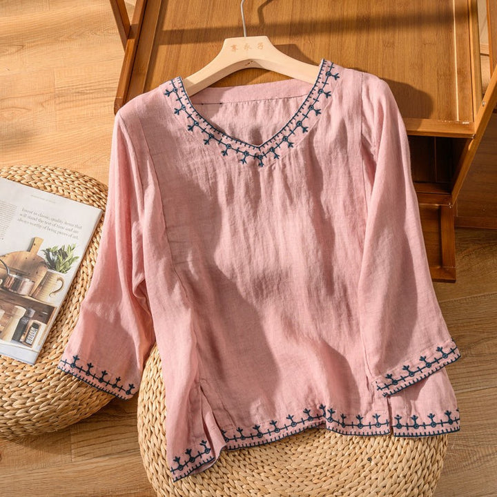 Pink linen blouse featuring embroidered trim and flared cuffs