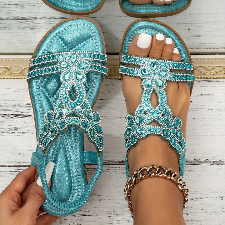 Close-up of teal beaded sandals showing crystal flower straps and cushioned footbed