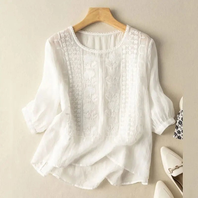 White floral embroidered blouse with three-quarter sleeves and round neckline