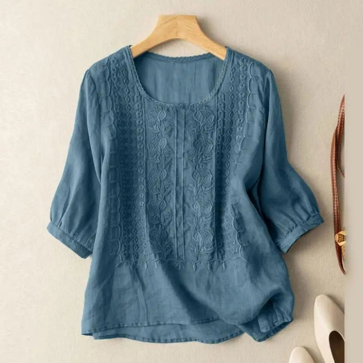 Blue floral embroidered blouse with three-quarter sleeves and asymmetrical hem