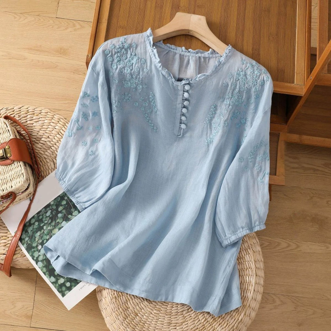 Light blue floral embroidered blouse with ruffle neckline and puff sleeves