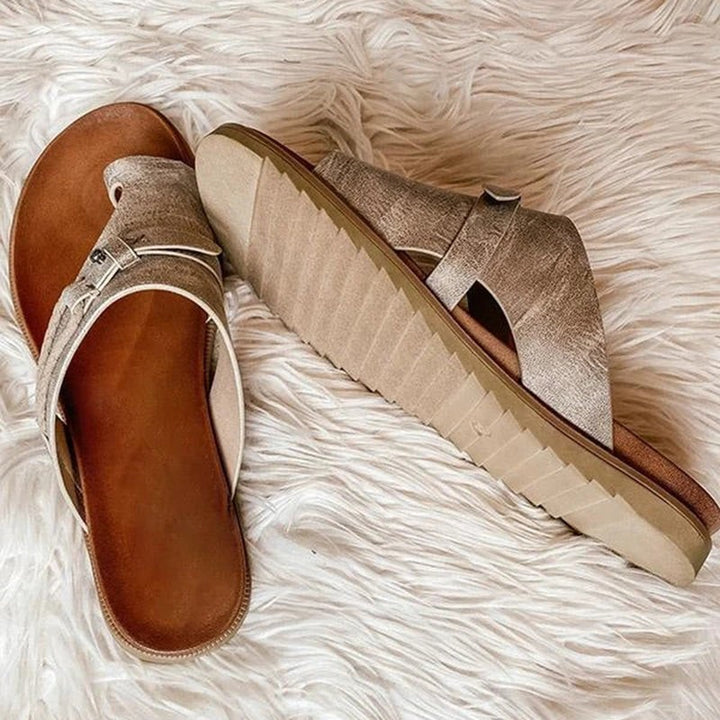 Metallic gold toe-ring sandals showing flat sole and buckle detail