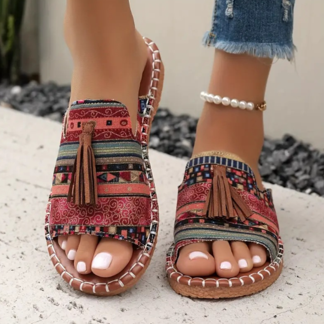 Red boho print flat sandals with tassel detail and stitched trim