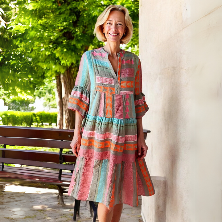 Model wearing flowy geometric print midi dress with bell sleeves outdoors