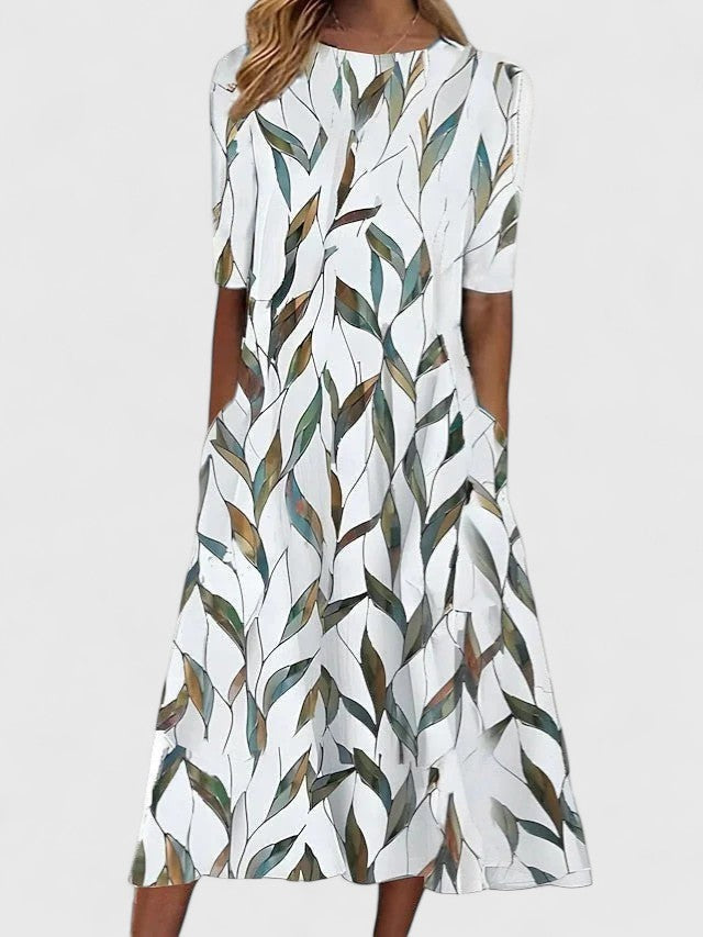 White midi dress featuring multicolor leaf print with round neckline