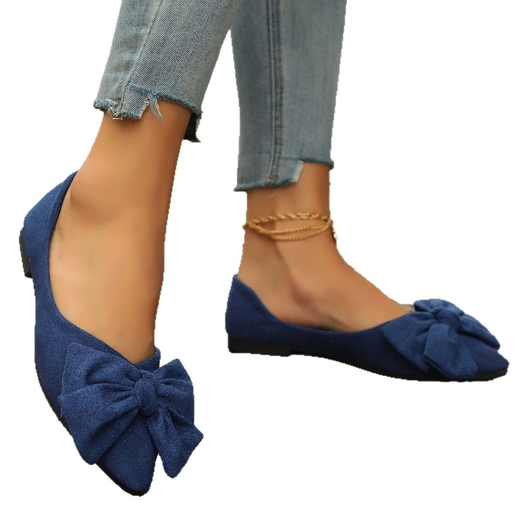 Navy suede pointed-toe ballet flats with bow detail worn with cropped jeans