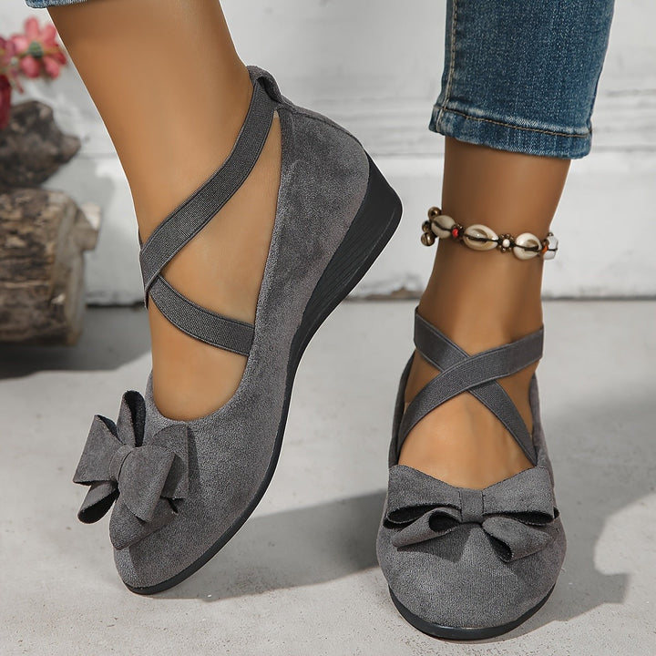 Gray suede wedge flats featuring bow accent and crisscross straps