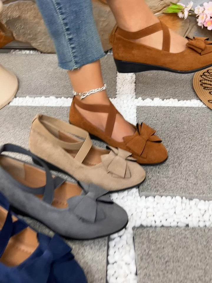 Assorted suede bow flats in brown, taupe, gray, and navy tones