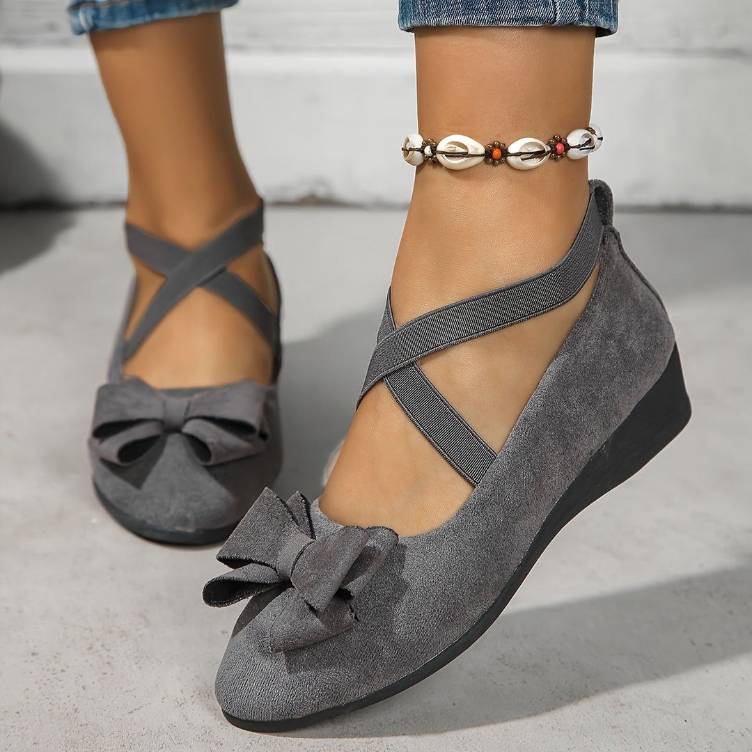 Gray suede ballet flats with bow trim and crossed ankle straps