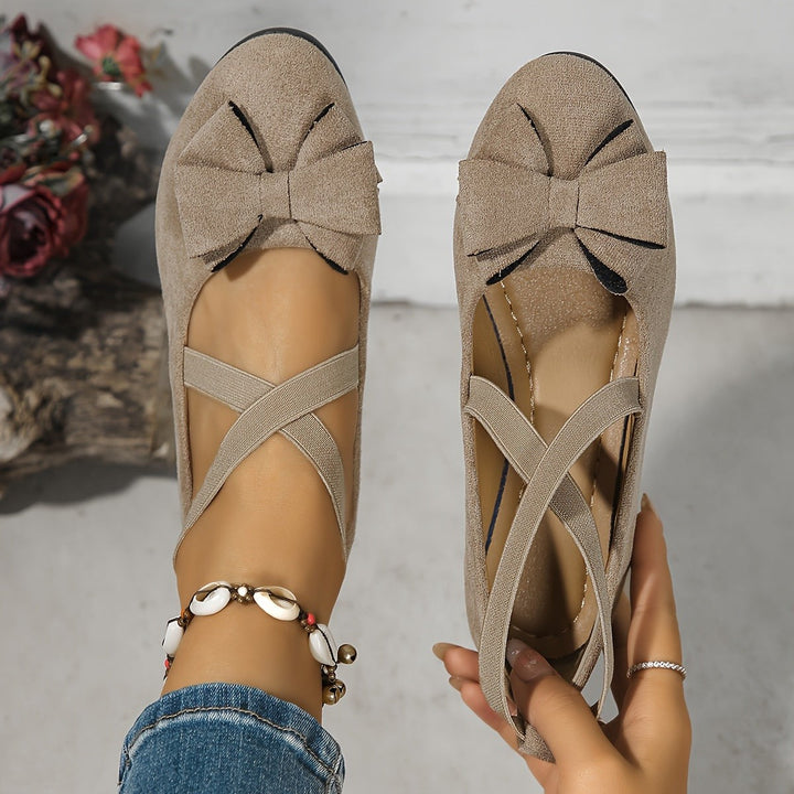 Taupe suede flats showing bow front and crossed elastic straps