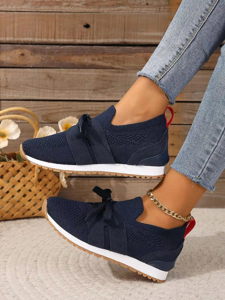 navy mesh slip-on sneakers featuring red pull tab and bow lace