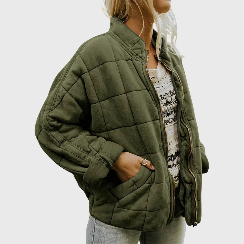 Khaki green quilted puffer jacket with stand collar worn over knitted jumper