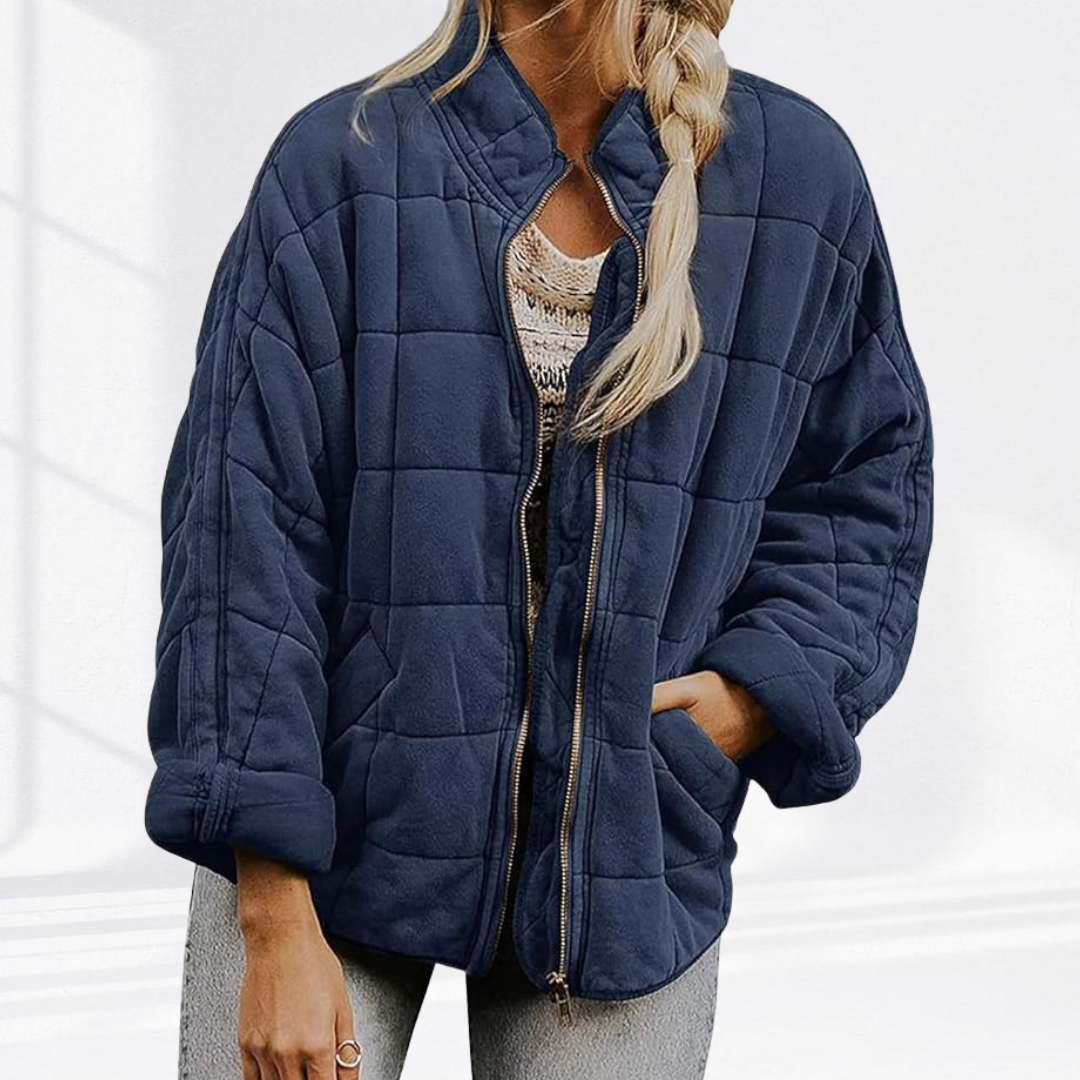 Steel blue quilted puffer jacket worn open over patterned knit top