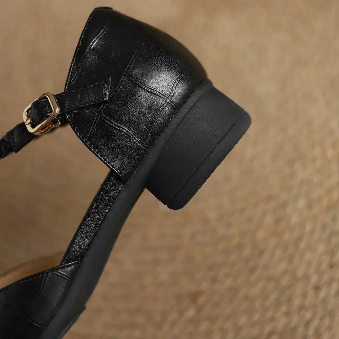 top-down view of black leather pointed toe flat with braided T-strap