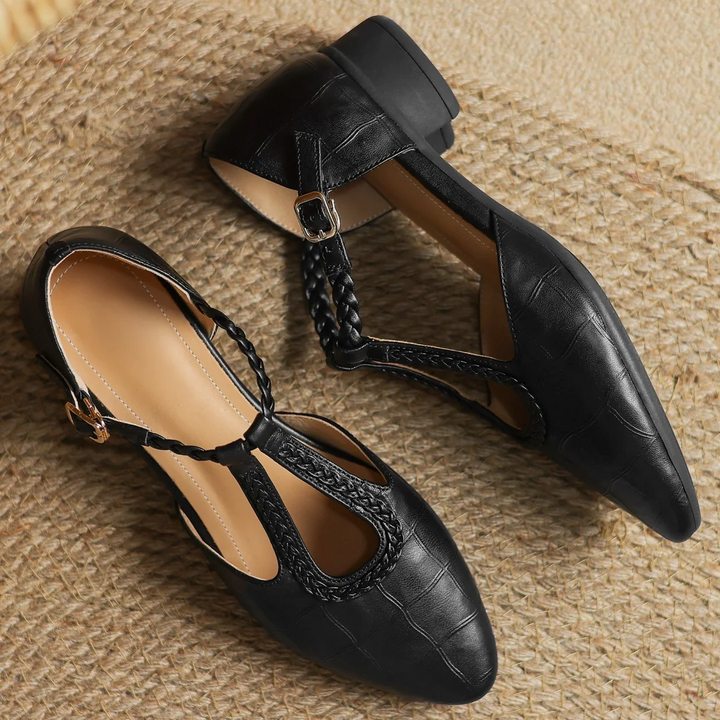 close-up of black leather flat heel with buckle strap and quilted texture