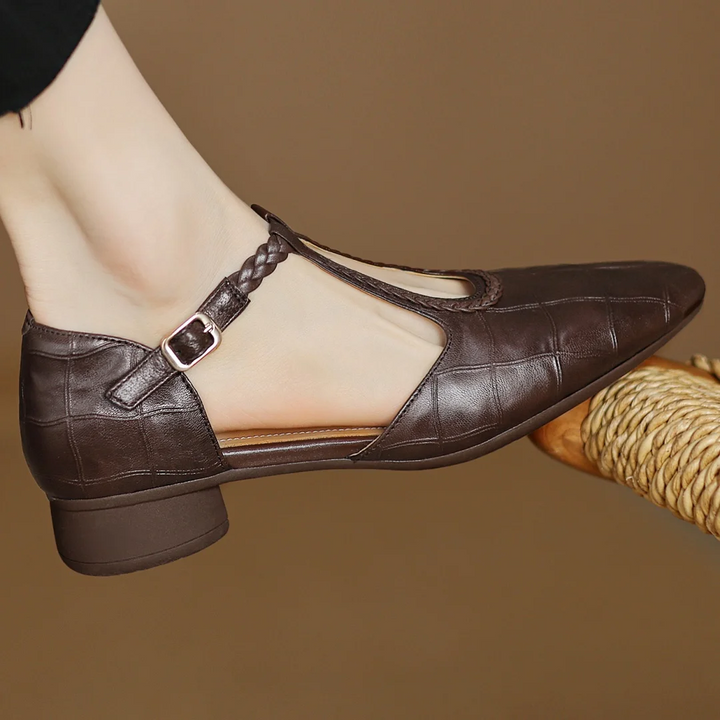 side view of brown leather pointed toe flats with woven ankle strap
