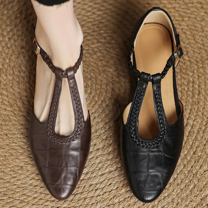 pair of brown leather T-strap flats with quilted texture and low heel