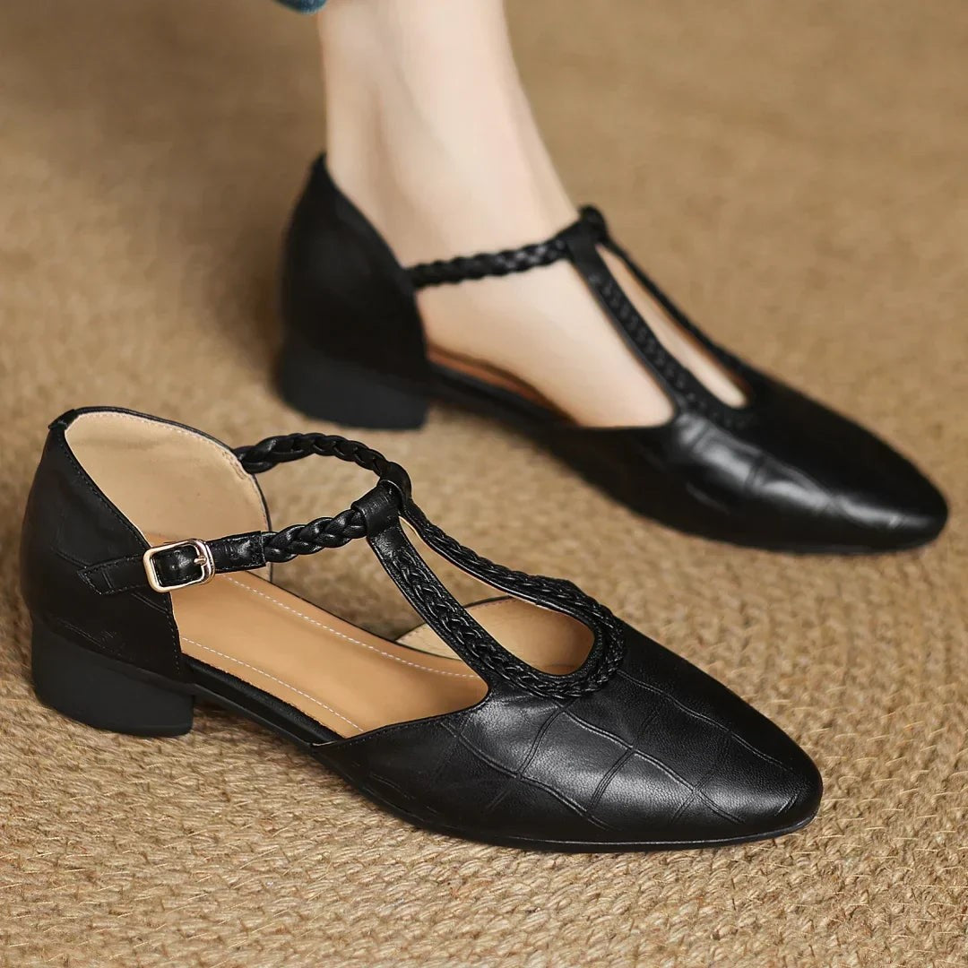 black leather T-strap Mary Jane flats worn with denim, pointed toe design