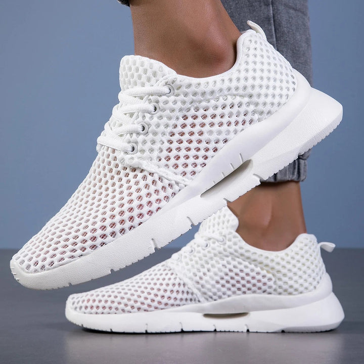 White mesh sneakers with lace-up front and lightweight cushioned sole