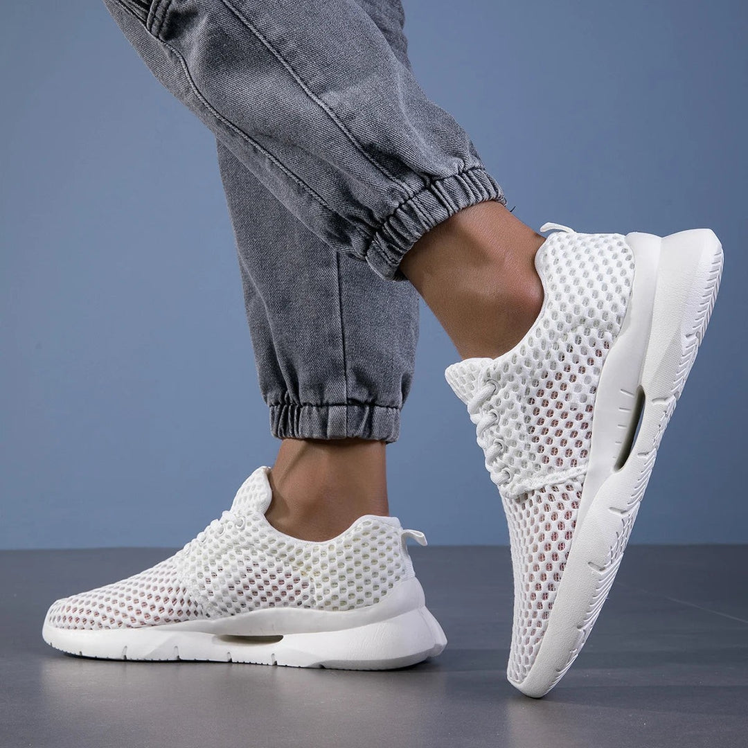 White mesh walking sneakers showing arch support cutout on sole
