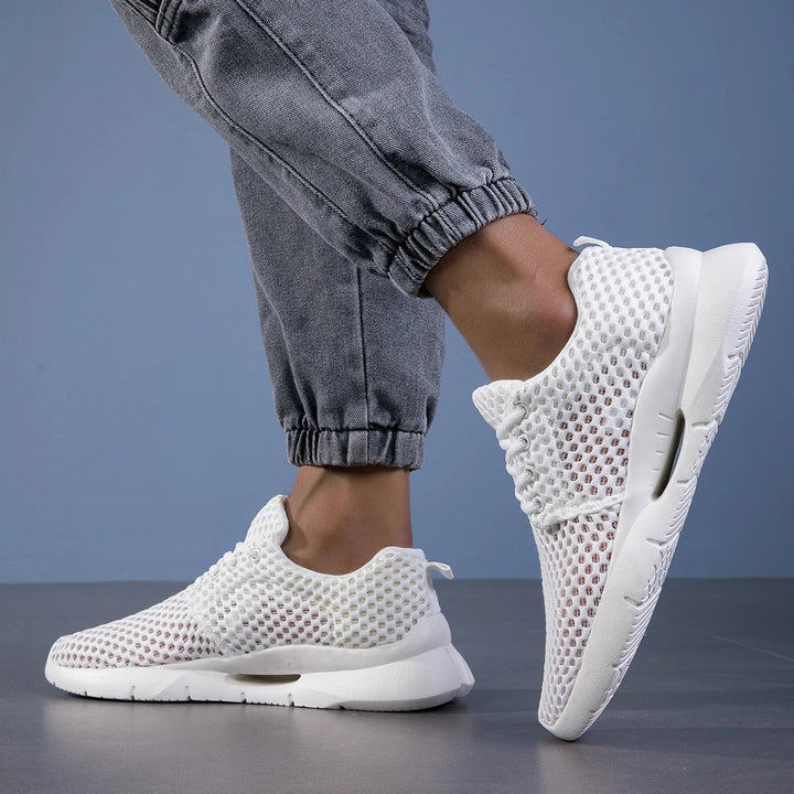White mesh walking sneakers showing arch support cutout on sole