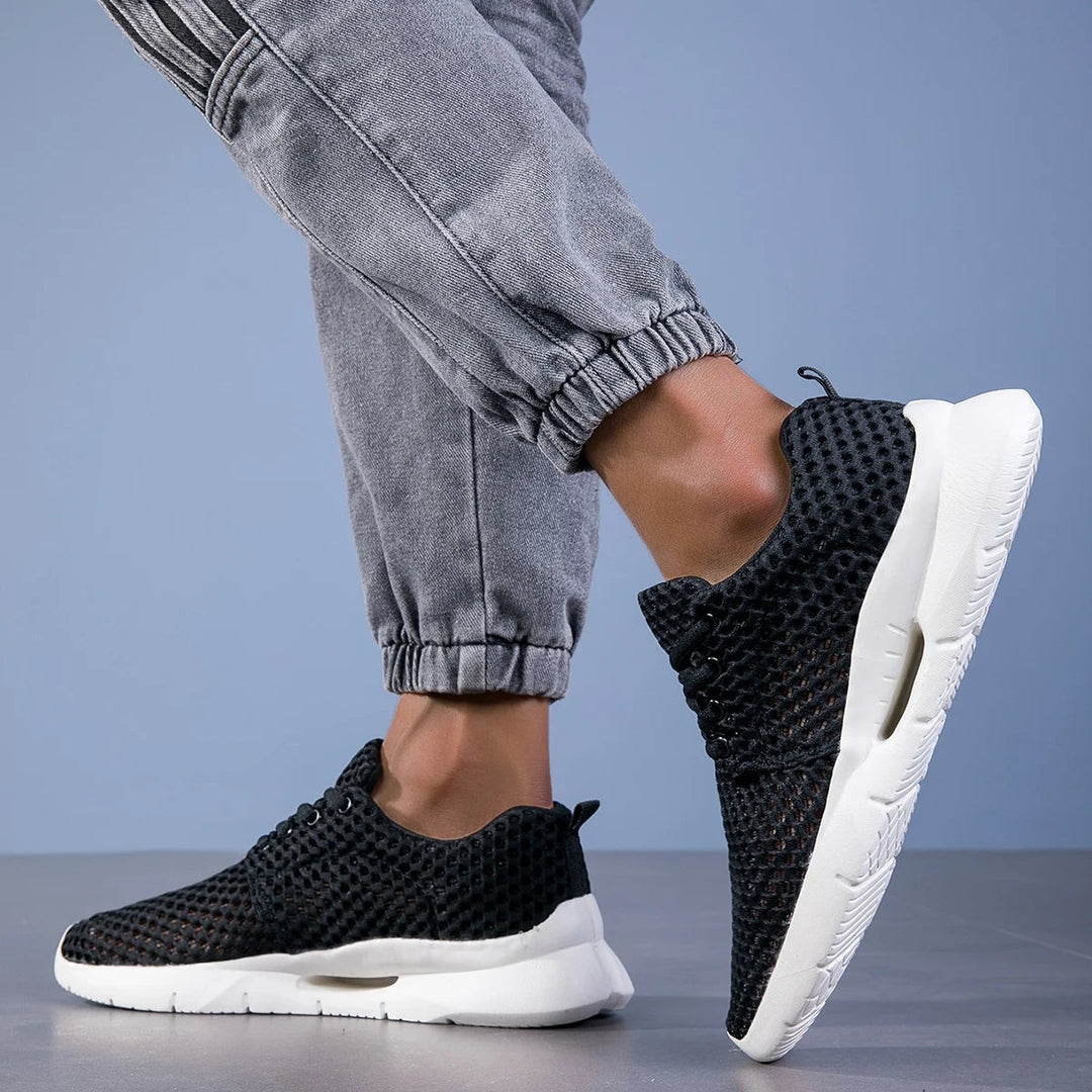 Black mesh walking shoes showing white cushioned midsole design
