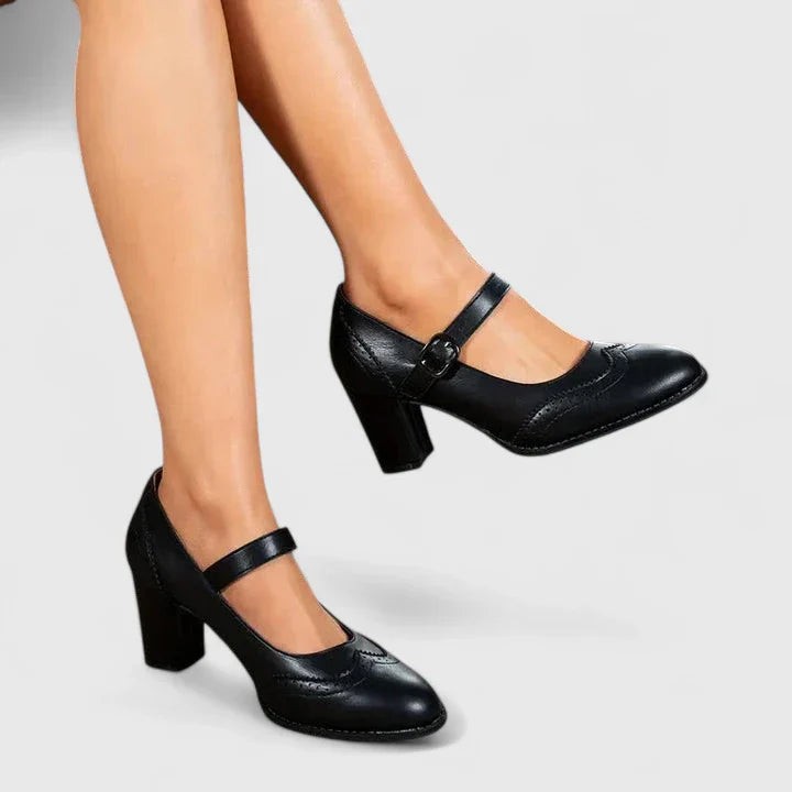 Black leather Mary Jane pumps with buckle strap worn on model's feet